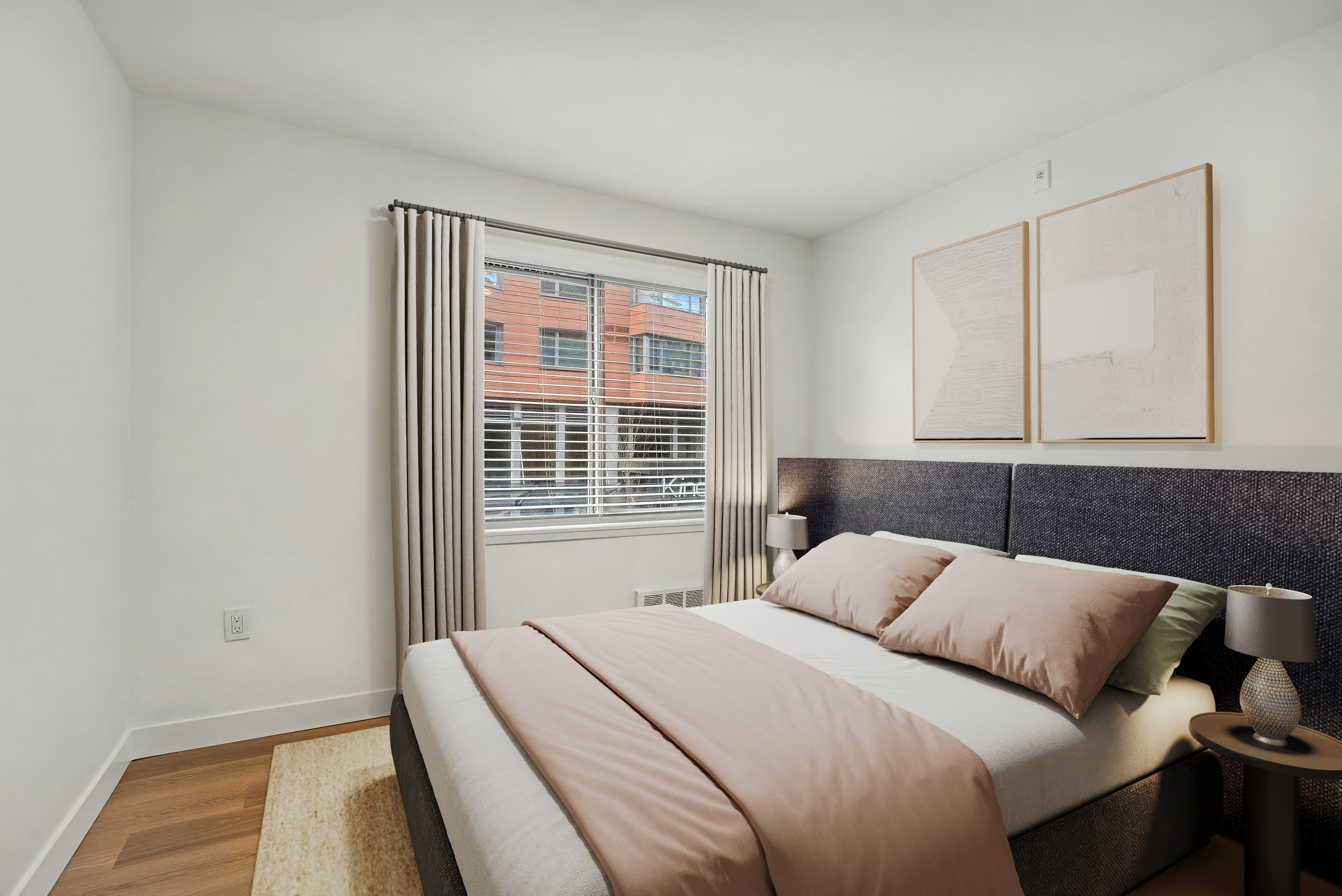 A bedroom with a large bed and a window with blinds.